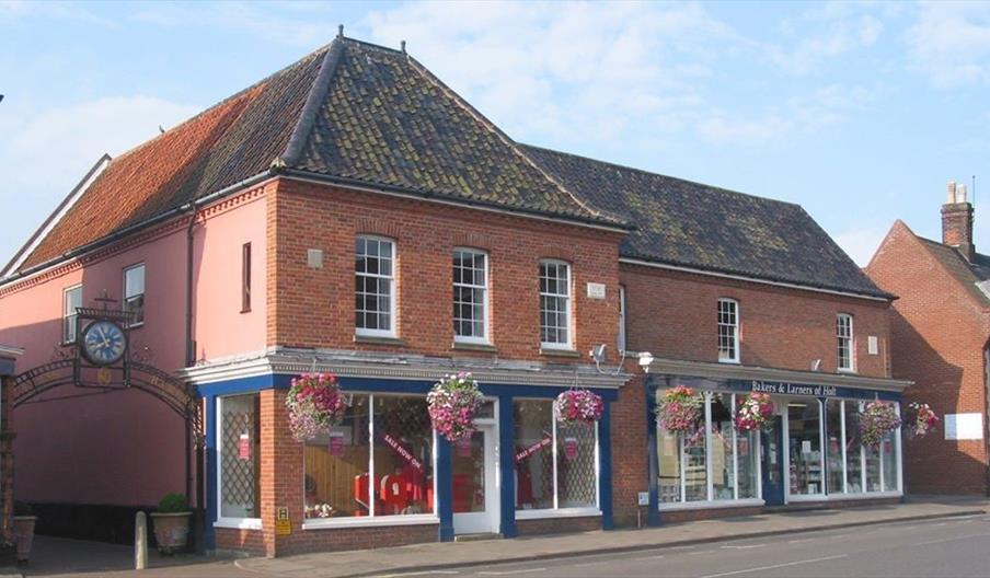 The Bakers and Larners of Holt shopfront on Market Place in Holt, Norfolk, with the heritage green fascia and the Georgian first-floor windows